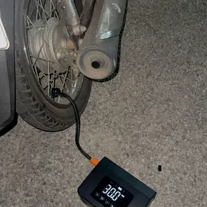 Compressor conectado ao pneu de uma moto à noite